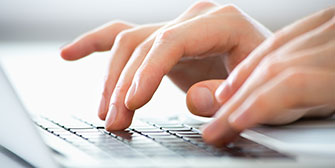 hands typing on a laptop