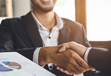 Man shaking another mans hand at a meeting