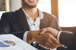 Man shaking another mans hand at a meeting