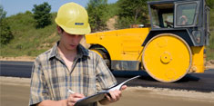 Guy in a hard hat looking at a clipboard
